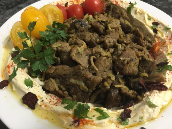 שווארמה רצועות  מסינטה  מוקפצת עם פטריות ובצלים על מצע חומוס